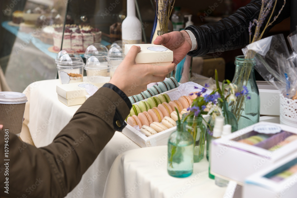 Obraz premium Woman purchasing a French macaron
