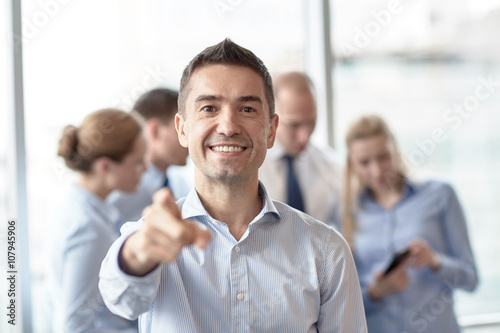 group of smiling businesspeople meeting in office