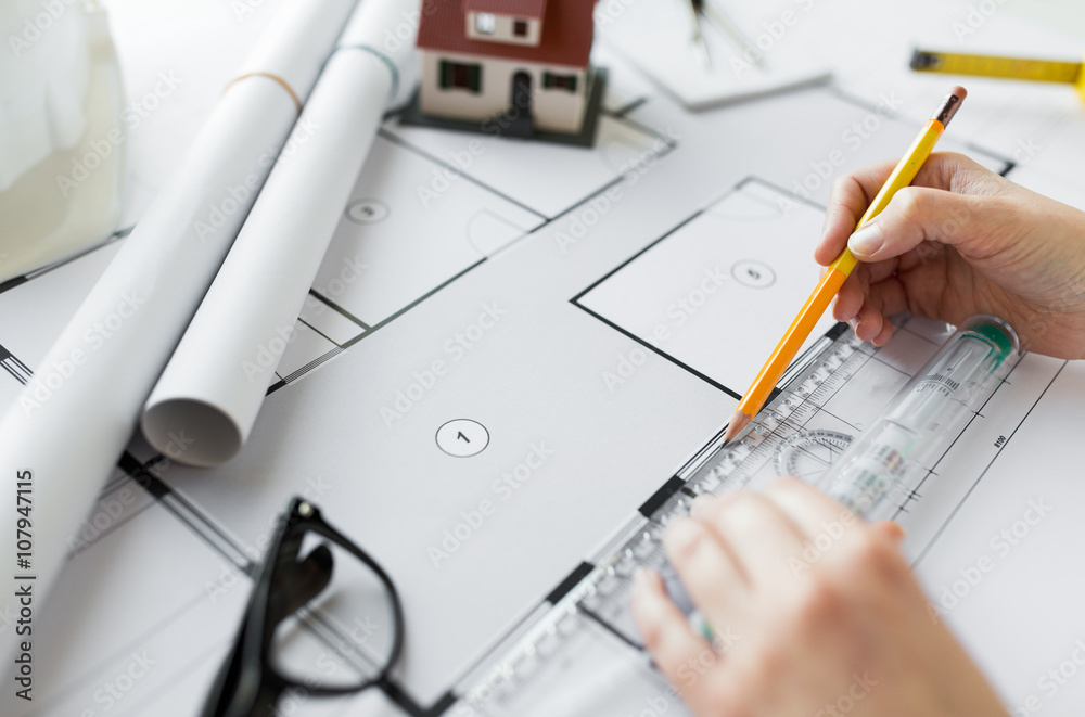close up of hands with ruler measuring blueprint close up of hands with ruler measuring blueprint