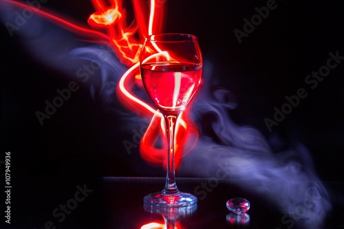 Glass of wine and red light painting