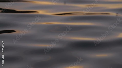 Closeup of river water at sunset in slow motion. Insects interact with the river ripples on a warm summers evening photo