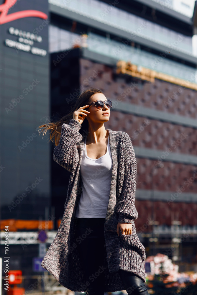 Fototapeta premium Beautiful girl in a cardigan, shirt and sunglasses outdoor