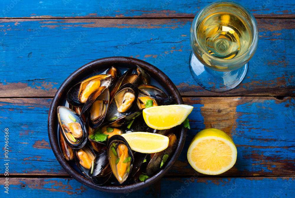 Mussels in clay bowl, glass of white wine and lemon Mussels in clay bowl, glass of white wine and lemon
