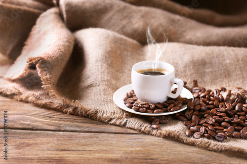 Cup of coffee with sackcloth on table close-up