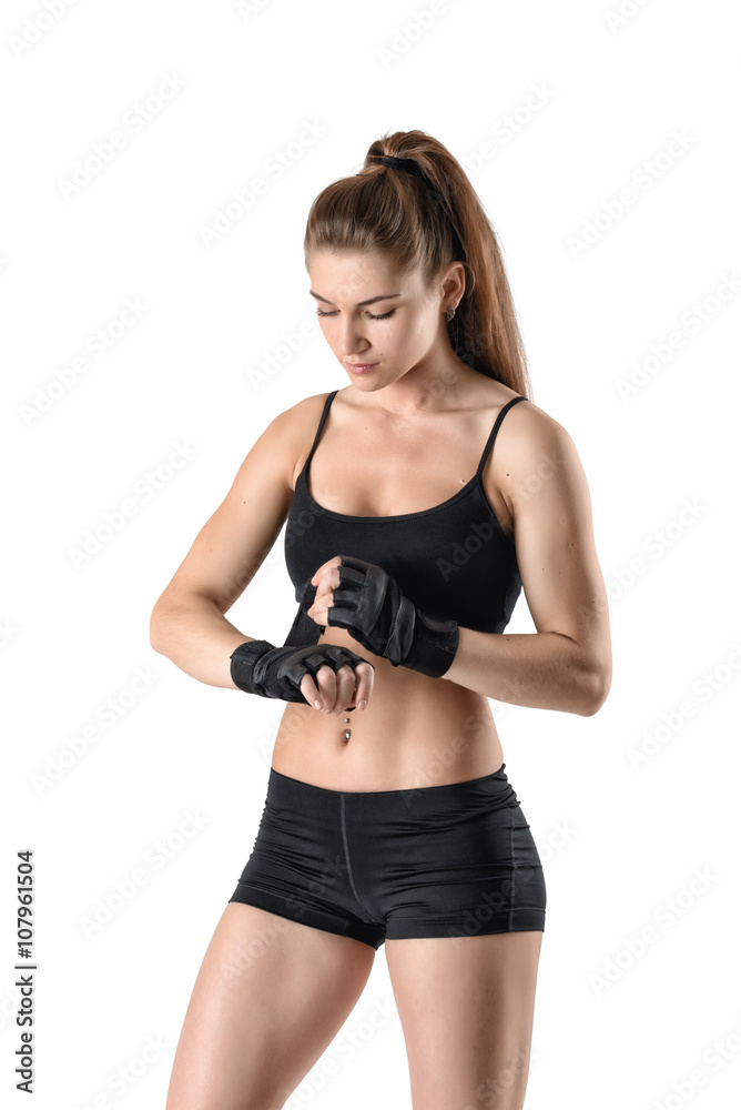 Strong female bodybuilder wearing gloves ready for gym exercise Strong female bodybuilder wearing gloves ready for gym exercise