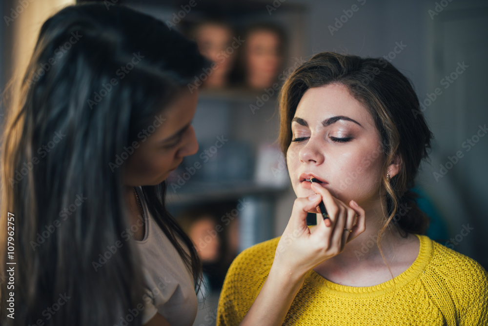 In the beauty salon, make-up artist doing make-up, hairdresser doing hairstyle, beautiful models In the beauty salon, make-up artist doing make-up, hairdresser doing hairstyle, beautiful models