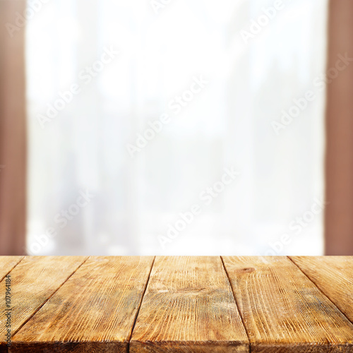 Empty wooden table and blurred window background