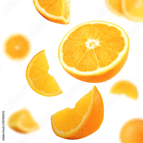 Falling ripe oranges isolated on white