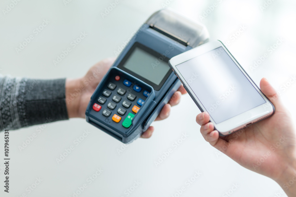 Woman using cellphone to pay with mobile phone