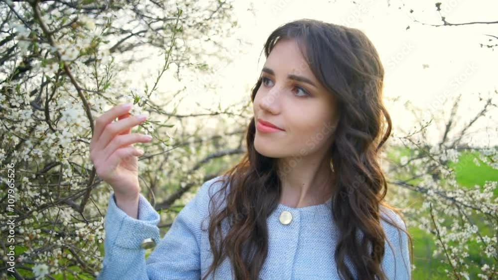 young pretty woman admires the blooming tree slow motion young pretty woman admires the blooming tree slow motion