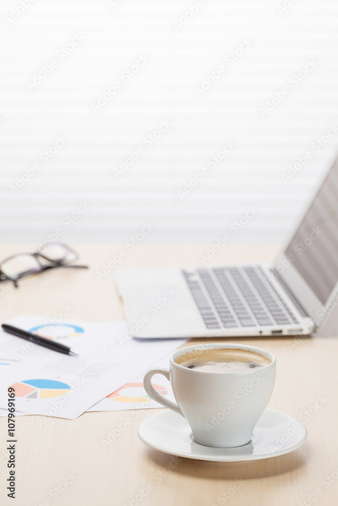 Office workplace with coffee, laptop and supplies Office workplace with coffee, laptop and supplies