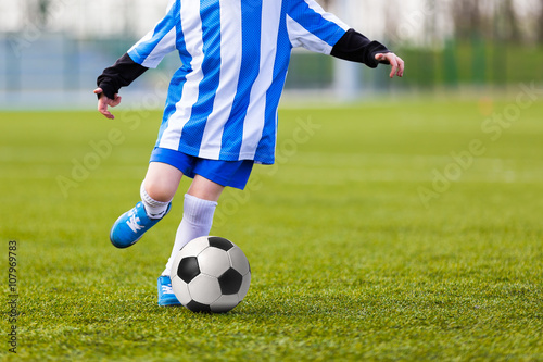 Fototapeta Naklejka Na Ścianę i Meble -  Child Young Boys Kicking Soccer Ball. Kid Playing Soccer.