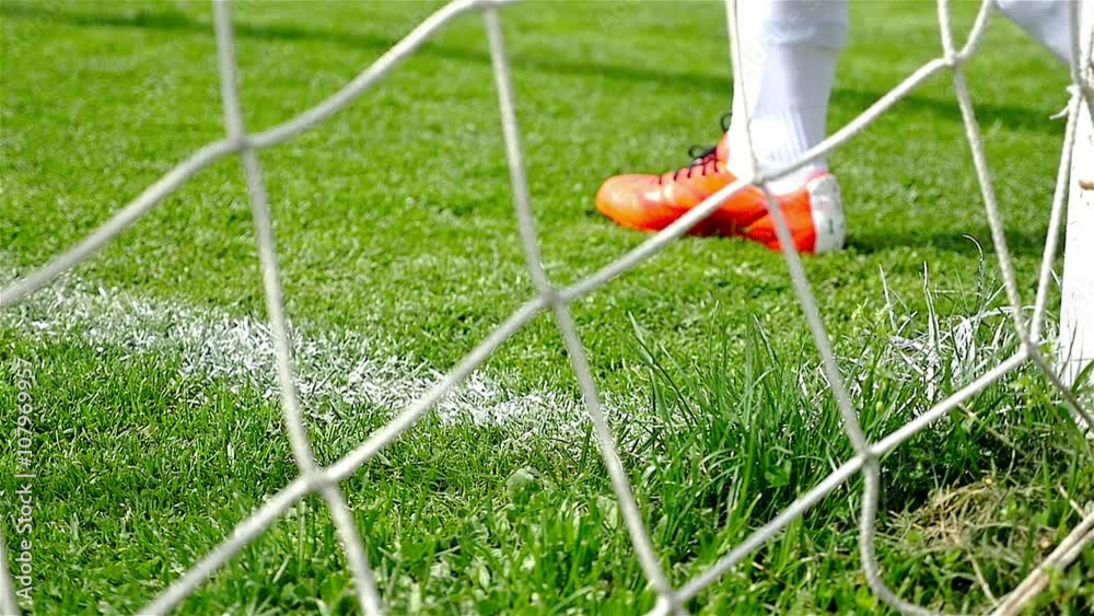 Slow motion of soccer player's feet passing in front of the goal line