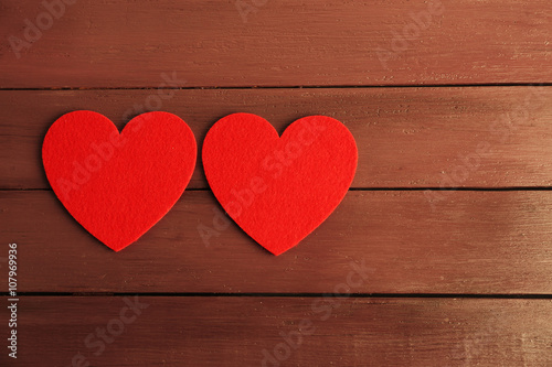 Red felt hearts on purple wooden background