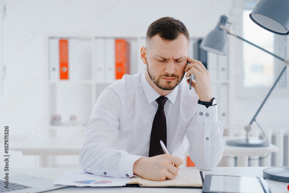 Businessman talking mobile phone in office 
