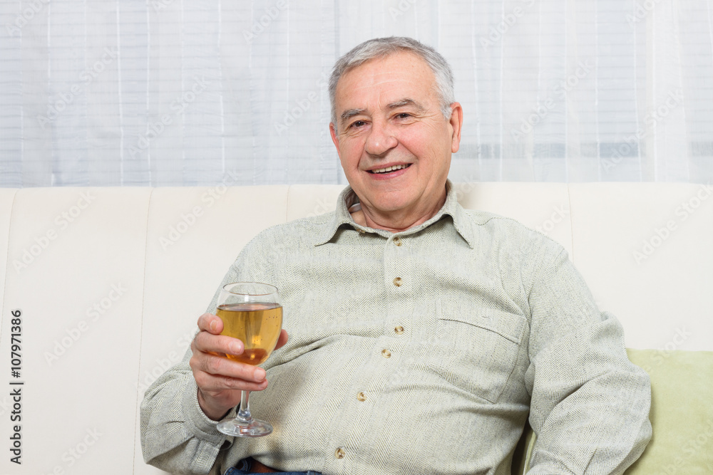 Senior man enjoys drinking wine at home. Senior man enjoys drinking wine at home.
