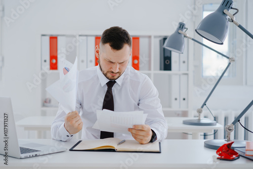 Tablou pe pânză confused businessman examines documents