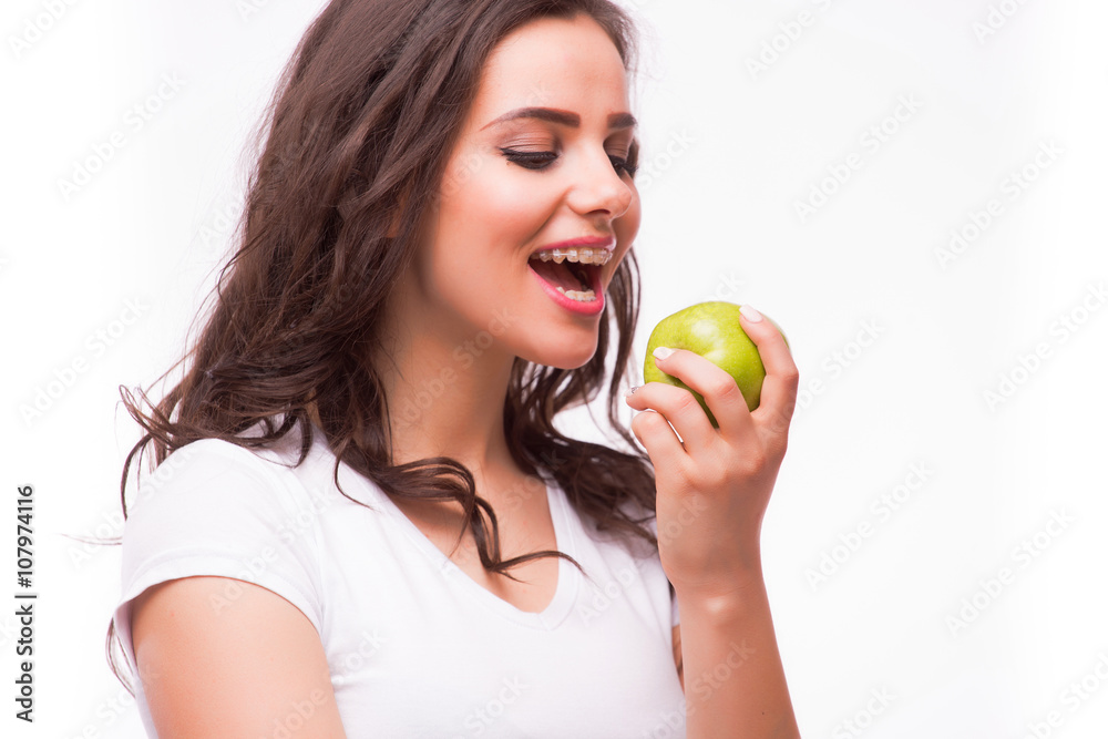 Young girl with brances eat apple. Female teeth with dental braces and apple. Healthy eating with braces Young girl with brances eat apple. Female teeth with dental braces and apple. Healthy eating with braces
