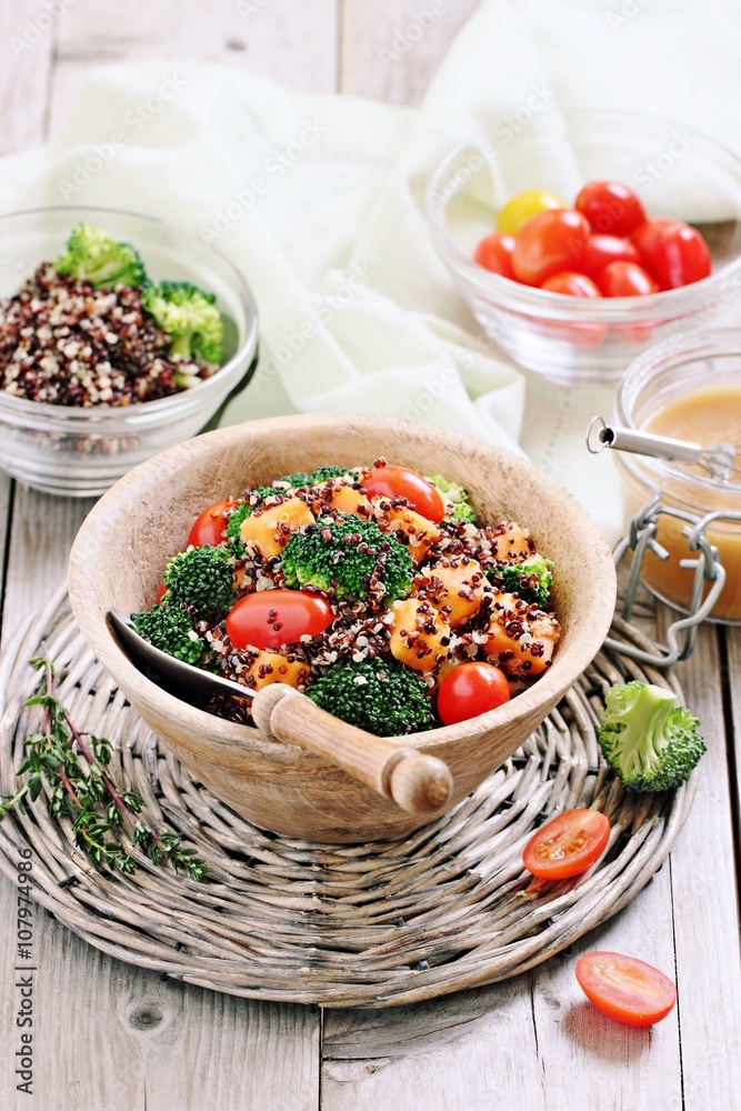 Quinoa salad with broccoli,sweet potatoes and tomatoes on a rustic wooden table.Superfoods concept.Selective focus Quinoa salad with broccoli,sweet potatoes and tomatoes on a rustic wooden table.Superfoods concept.Selective focus