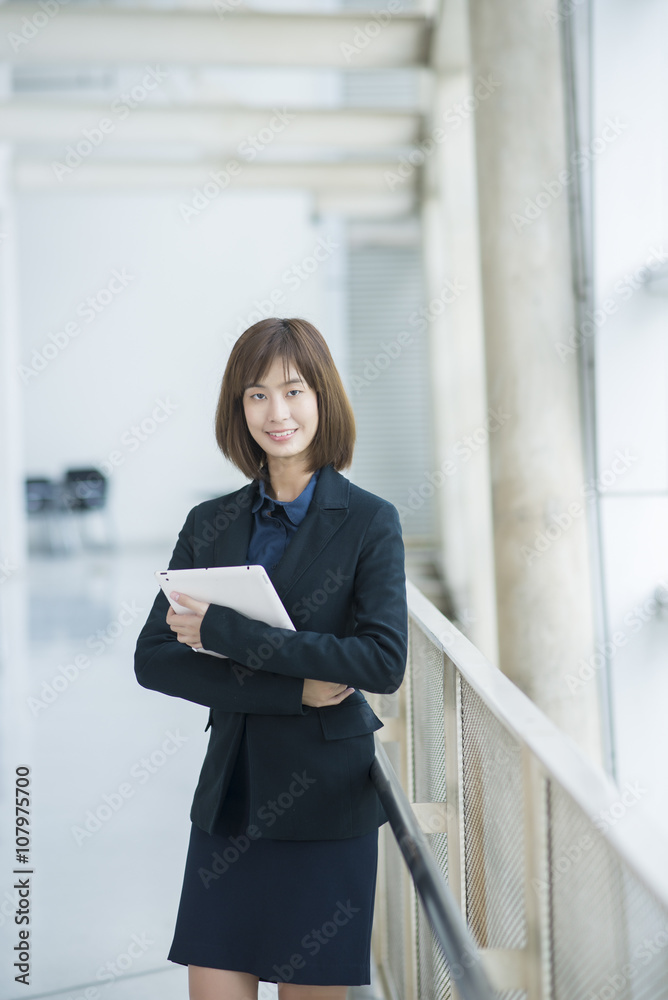 Attractive asian business woman working on tablet computer outsi