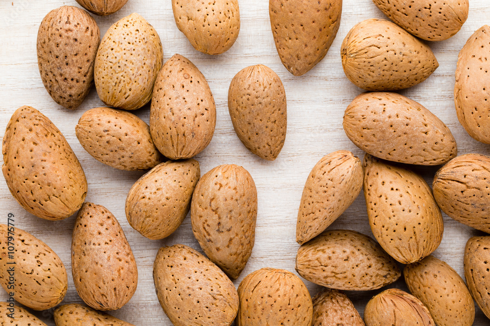 Group of almond nuts with leaves.Wooden background. Group of almond nuts with leaves.Wooden background.