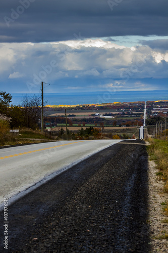 the view down a scenic country roadway in autumn landscape