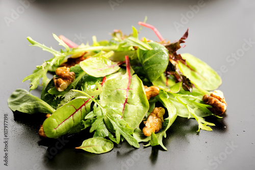 Salad mix with rucola, frisee, radicchio, lettuce and nuts on pl