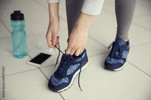 Woman tying up running shoe