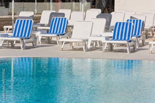 Hotel Poolside Chairs near a swimming pool © dvoevnore