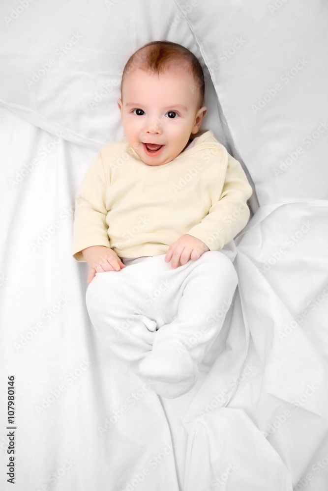 Loving baby lying on soft bed, close up Loving baby lying on soft bed, close up