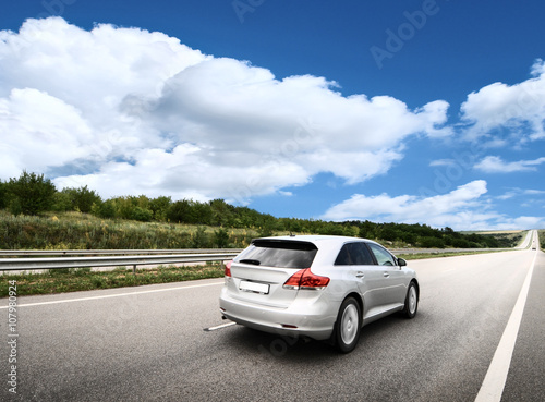 Driver's hands on a steering wheel of a car and blue sky