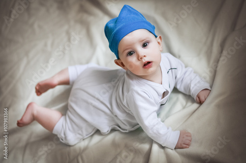 Cute 6 month baby with blue hat and smurf costume on beige background Stock  Photo | Adobe Stock