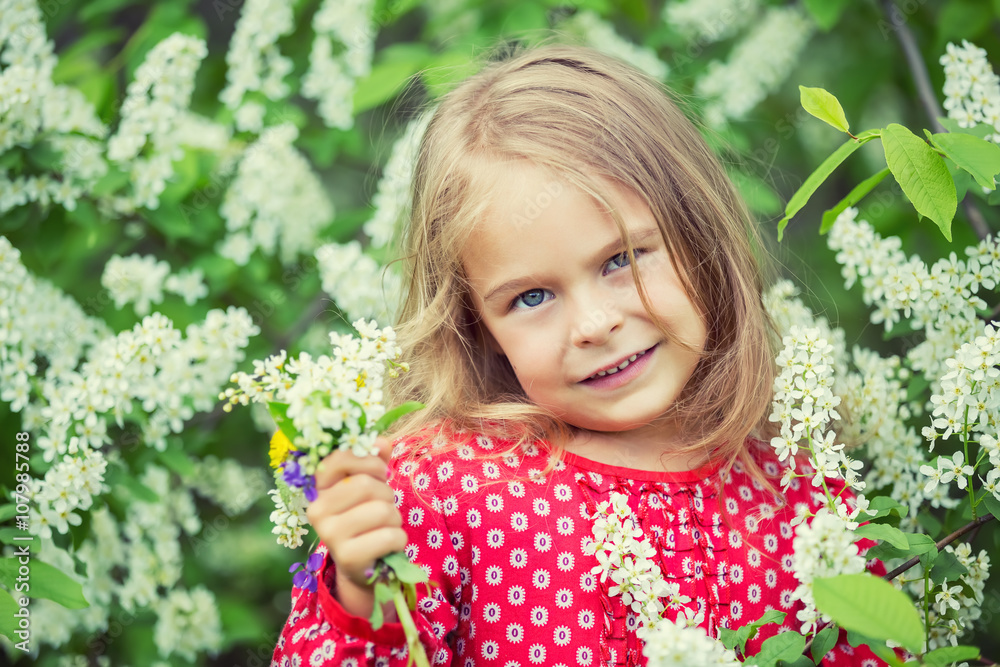 Portrait of happy little girl in spring flowers Portrait of happy little girl in spring flowers