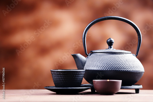 Black pialats and teapot on blurred background