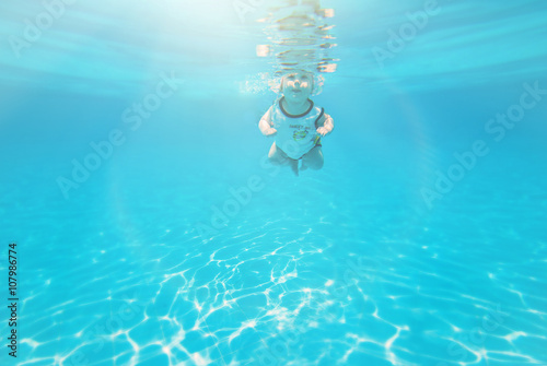 Summer vacation! A baby girl is diving in pool