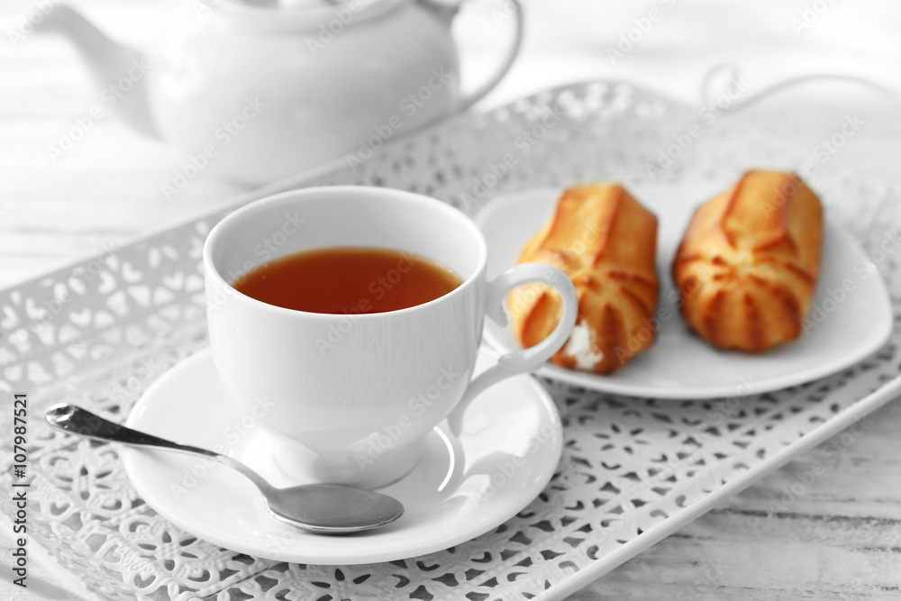 Tea with pastries filled with custard on the tray Tea with pastries filled with custard on the tray