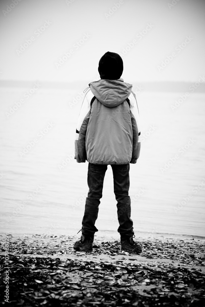 Rear view on boy facing lake