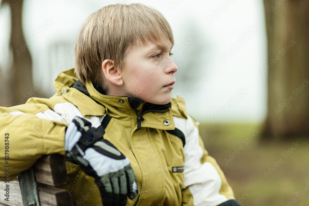 Profile of serious boy in coat and gloves Profile of serious boy in coat and gloves