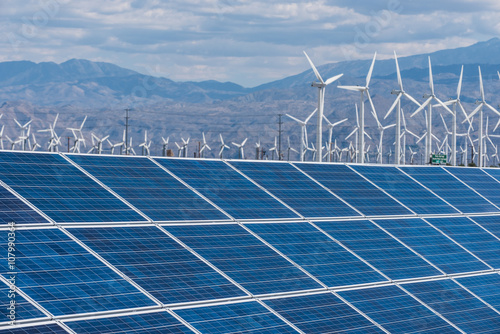 Solar panels and wind turbines in sunny desert