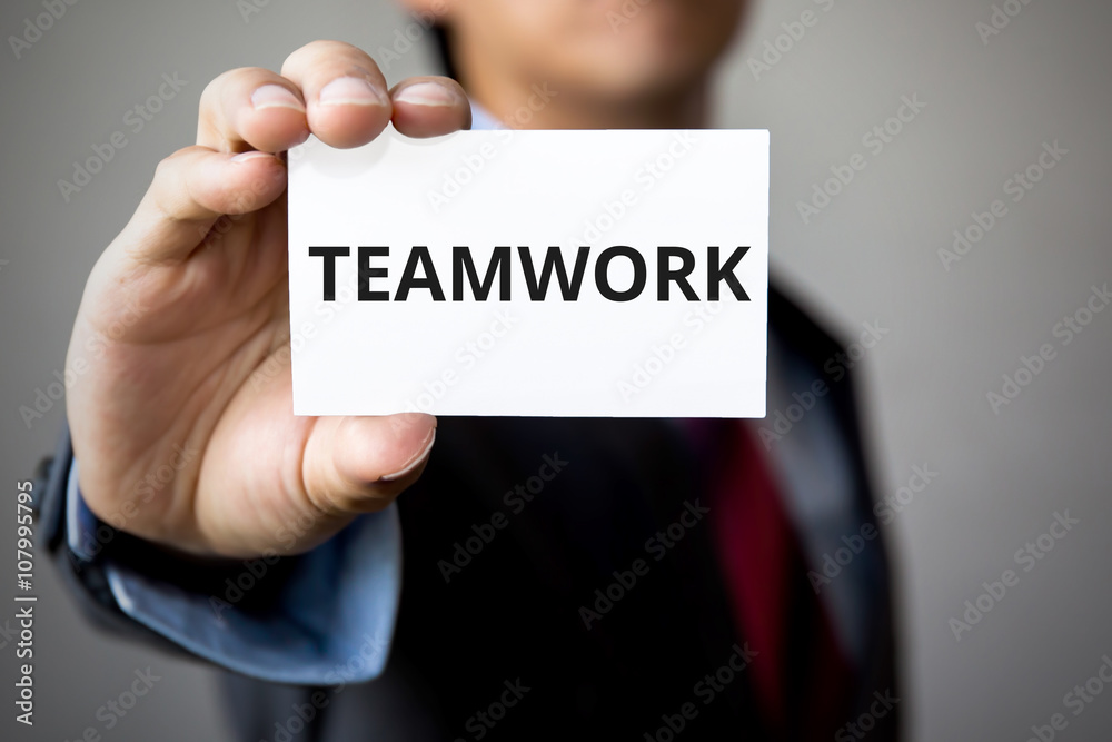 Businessman presenting 'TEAM WORK' word on white card Businessman presenting 'TEAM WORK' word on white card