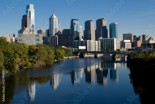 The skyline of Philidelphia. The Schuylkill river is in the foreground. The tallest buildings are on the left side. The buildings are reflected in the surface of the river.    © Aneese