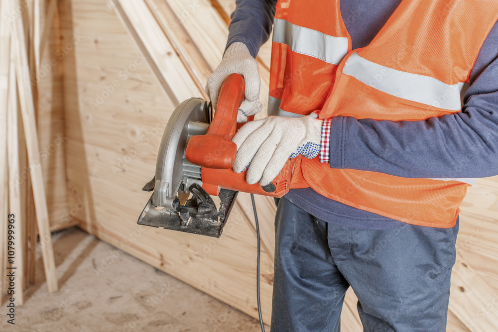 Gloved hands holding a power tool Gloved hands holding a power tool