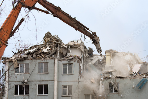 Demolition of a residential house using building hydraulic shears photo