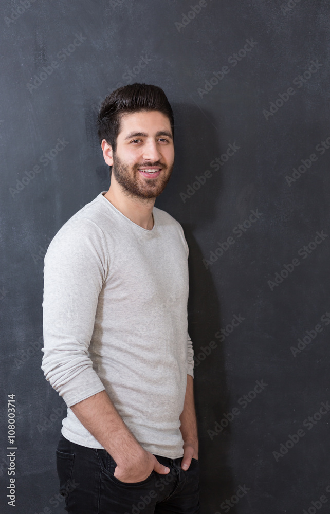 Studio picture of a young and handsome man posing on chalkboard