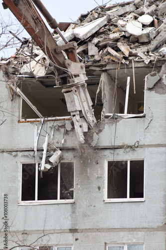 Demolition of a residential house using building hydraulic shears photo