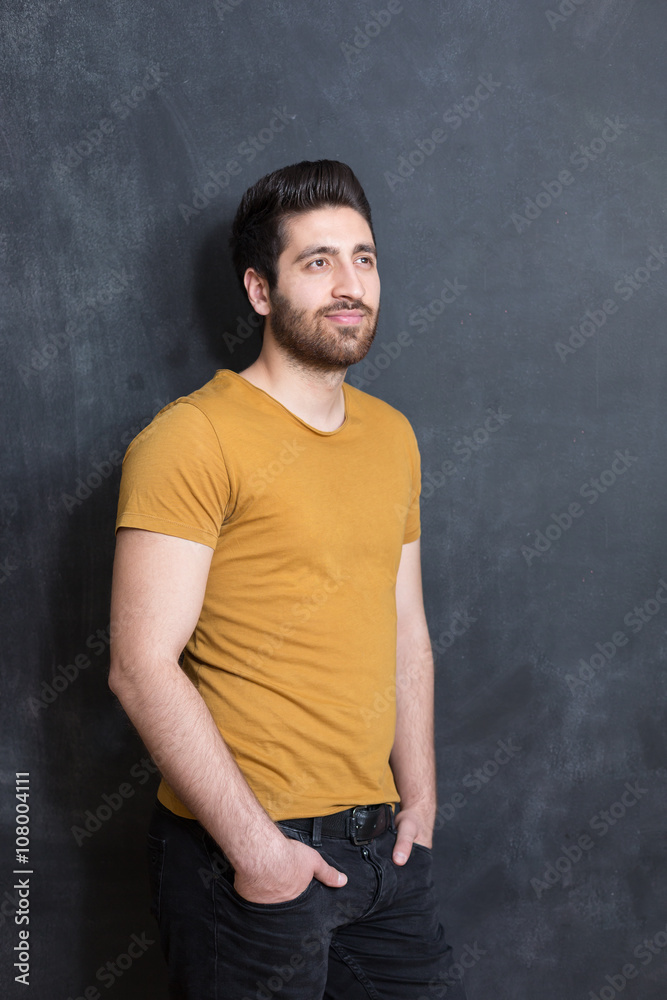 Portrait of a fashionable young man on dark background, chalkboa