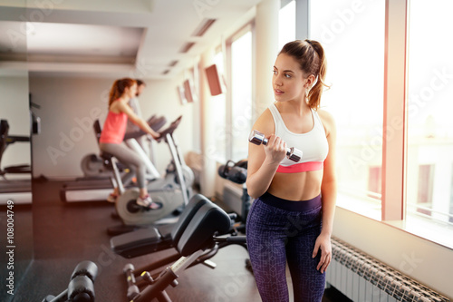 Beautiful woman lifting weights in gym