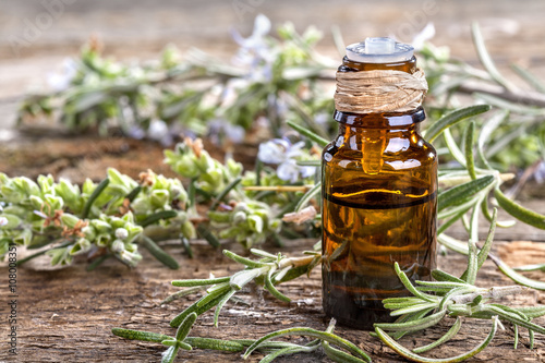 Essential oil made from rosemary on rustic table