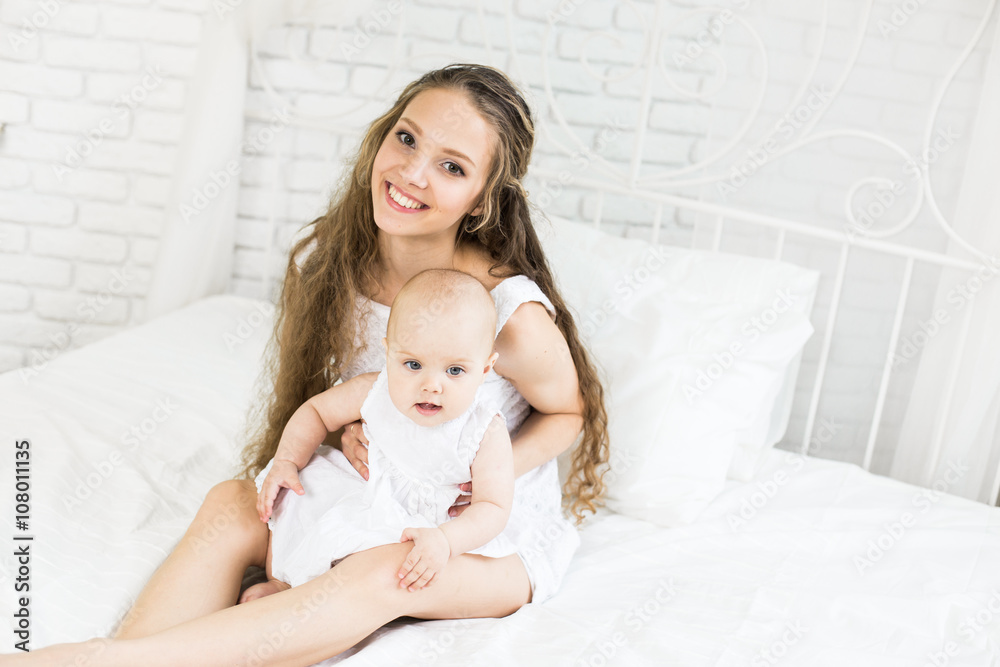 happy family. mother playing with her baby in the bedroom.