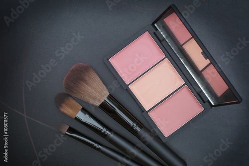 dark tone selective focus on beautiful peachy cheek blusher kit photo